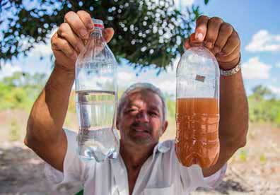Un miembro de una comunidad de MATOPIBA muestra dos botellas de agua: una con agua limpia, la otra con agua de un río, que está sucia con sedimentos de las plantaciones de soja. El sedimento también contiene agrotóxicos, lo que hace que el agua ya no sea potable. Rosilene Miliotti/FASE